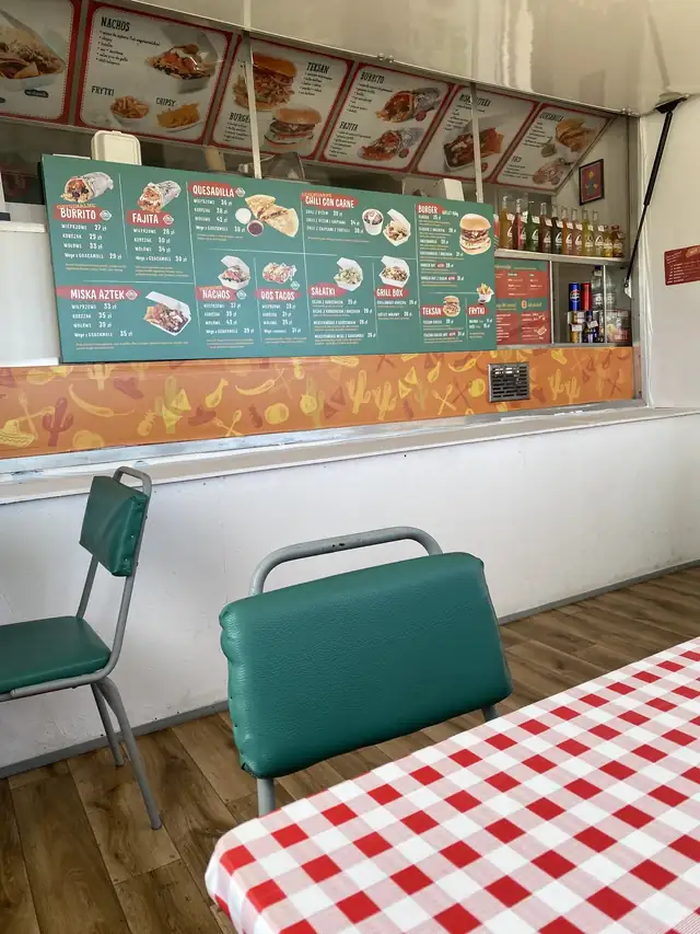 W środku: tablica menu i kraciaste obrusy